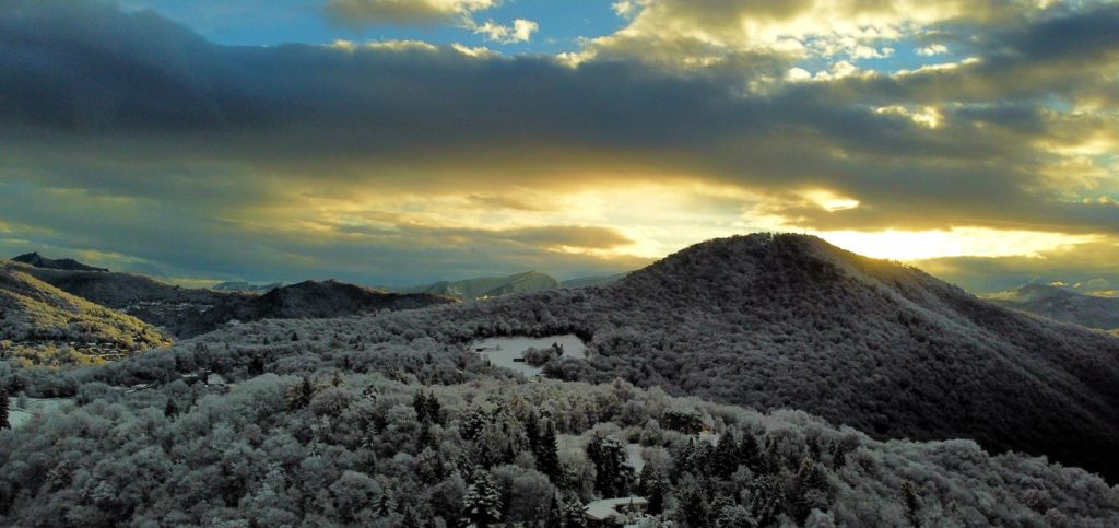the sun is setting over a snowy mountain range
