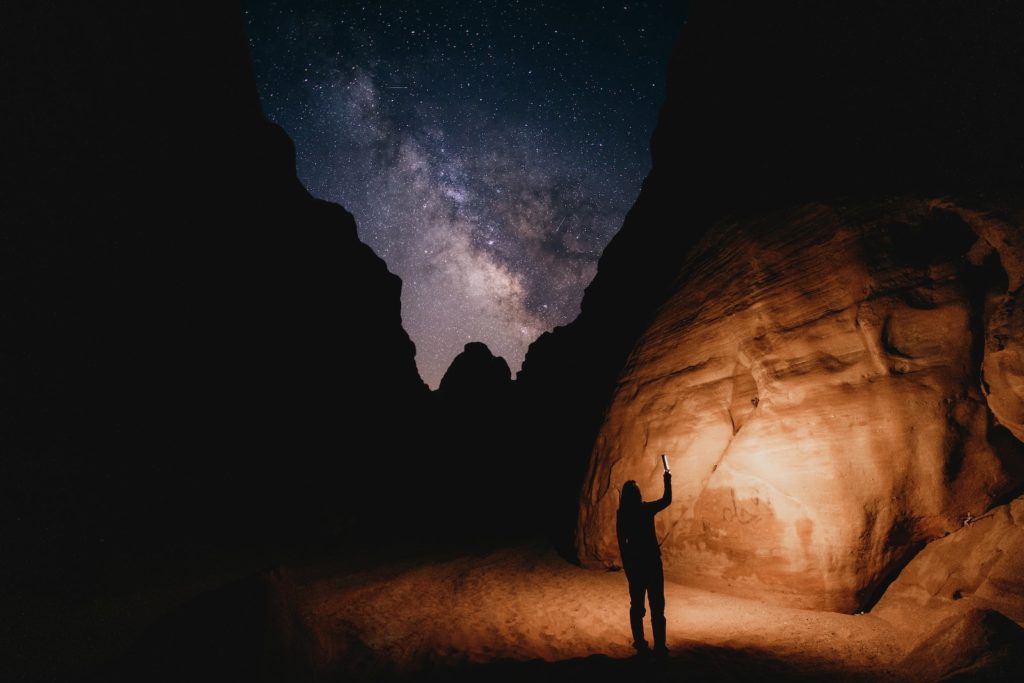 a man standing in the middle of a desert at night