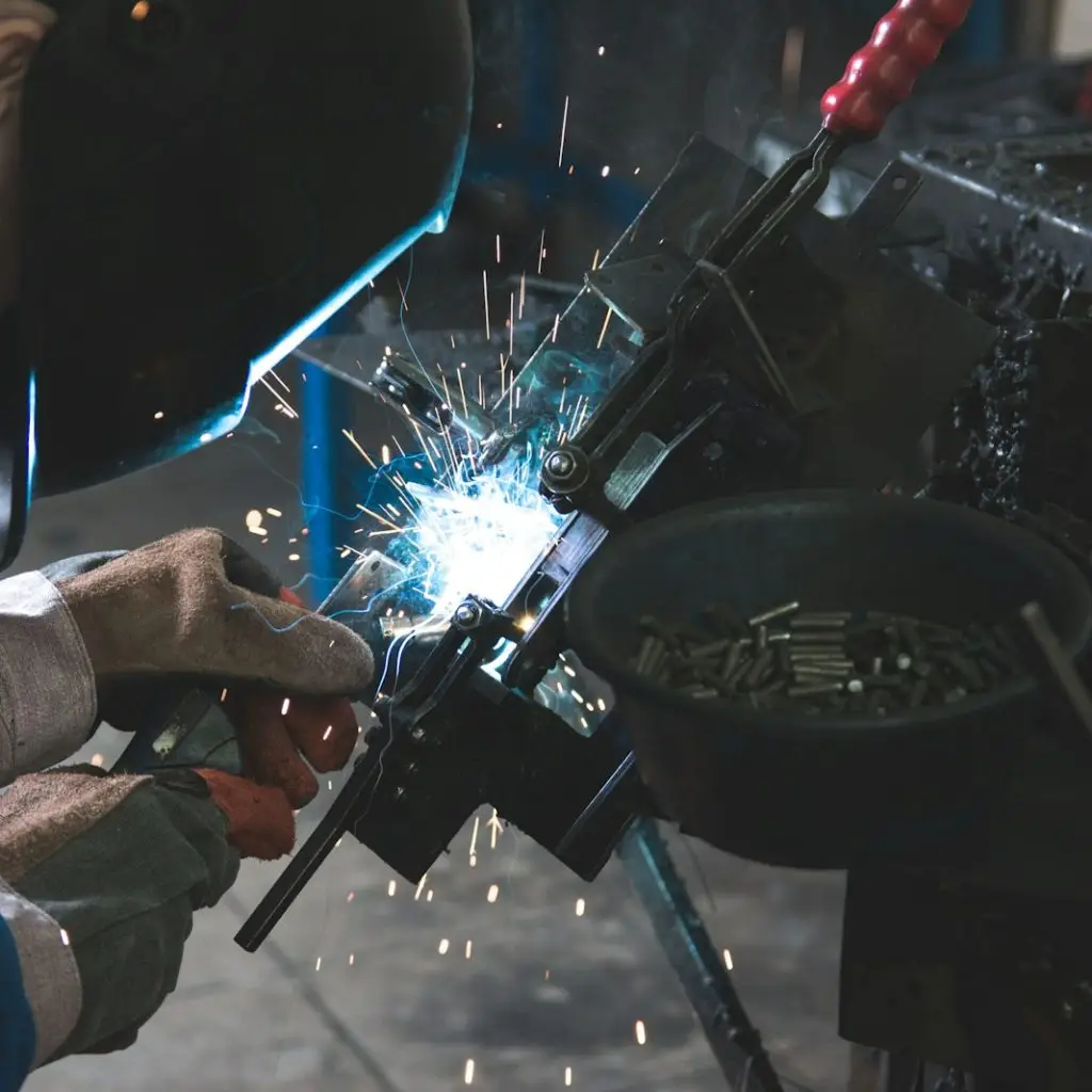 man welding a black metal