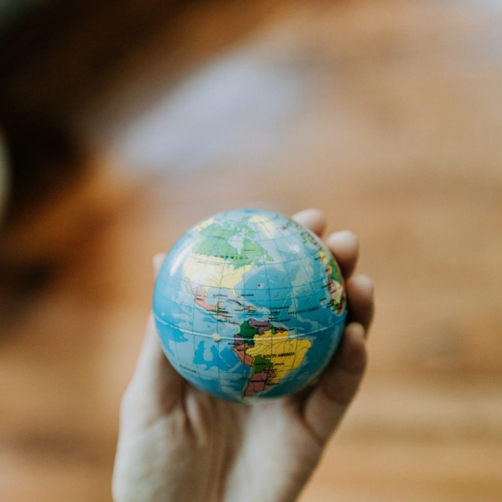 a person holding a small globe in their hand