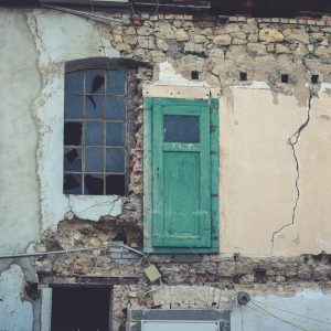 an old building with a green door and window